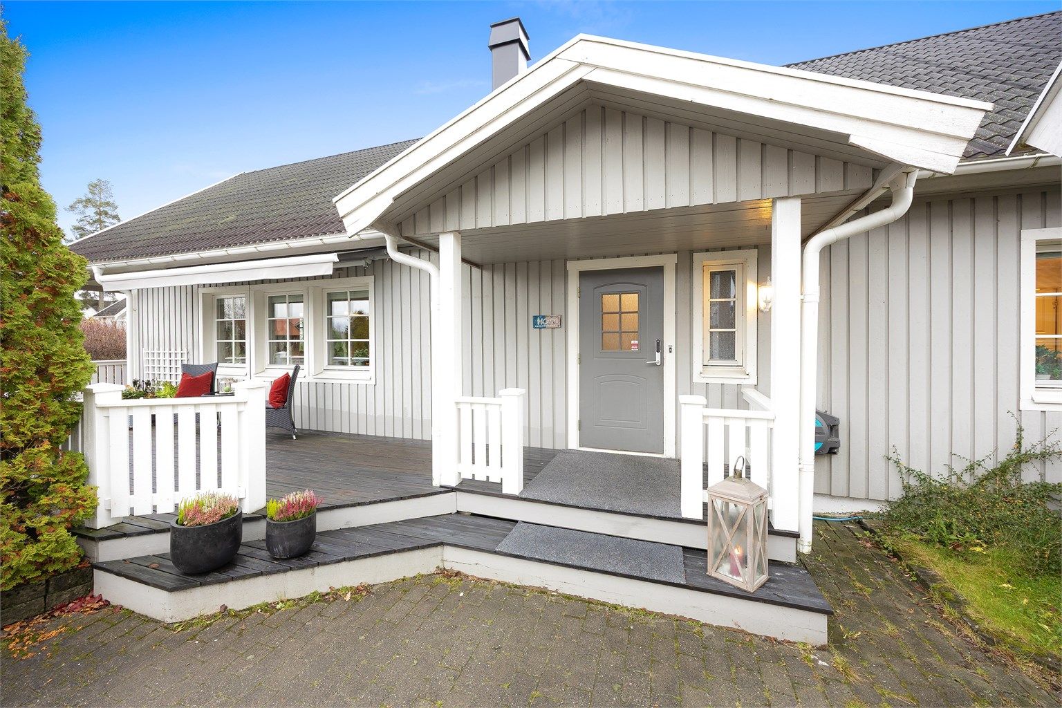 Boligen ønsker deg velkommen med en hyggelig innkjørsel med belegningsstein og et overbygget inngangsparti