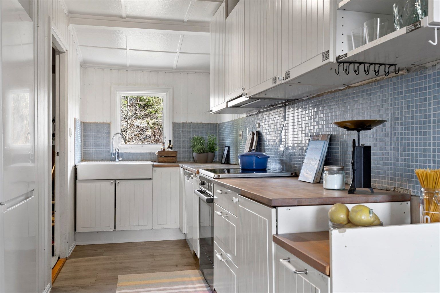 Kjøkkeninnredning fra IKEA med benkeplate i heltre og stor porselenskum.