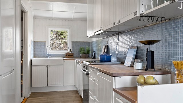 Kjøkkeninnredning fra IKEA med benkeplate i heltre og stor porselenskum.