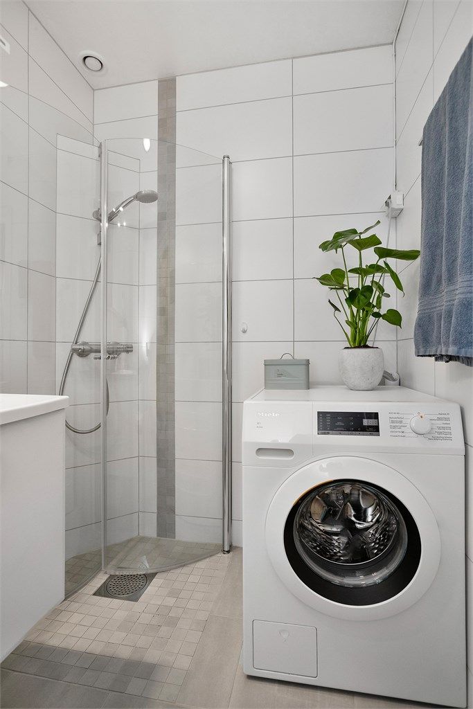 Badet har opplegg for vaskemaskin og en praktisk dusjnisje med buede glassdører.