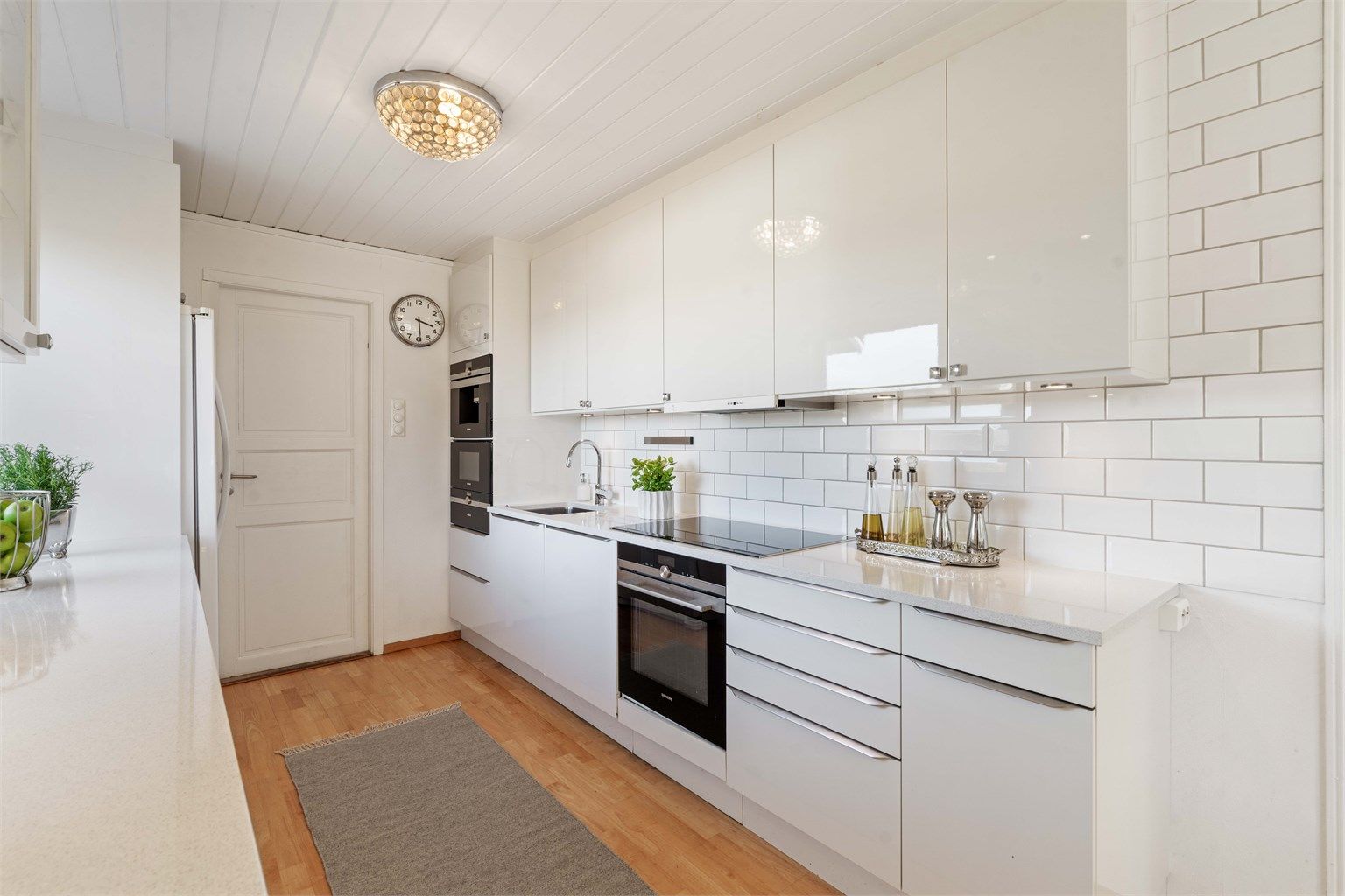 Kjøkkeninnredningen har slette, høyglansede fronter og godt med arbeidslys fra downlights.