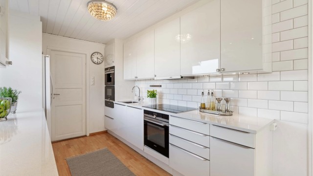 Kjøkkeninnredningen har slette, høyglansede fronter og godt med arbeidslys fra downlights.