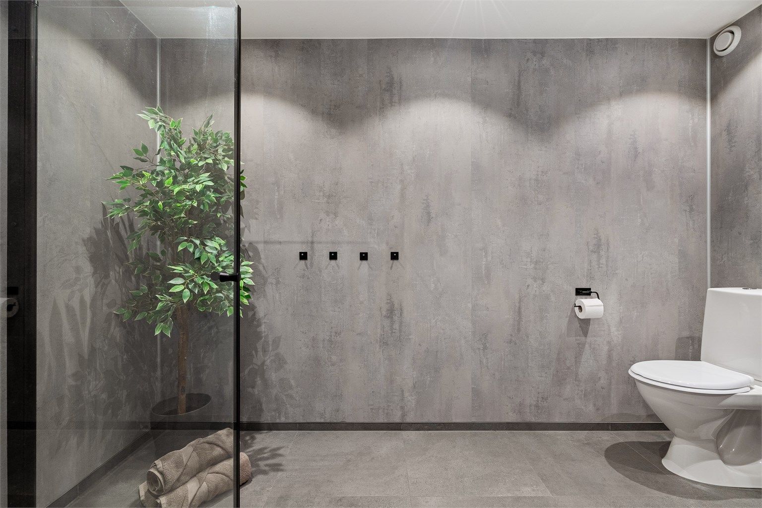 Veggene på bad ble revet til stendere og ordnet ny membran, baderomsplater, nytt tak med spotter og nye fliser på gulv. Toalett, dusjhjørne med innfellbare dører og servant med skuffer. Speil på vegg.  