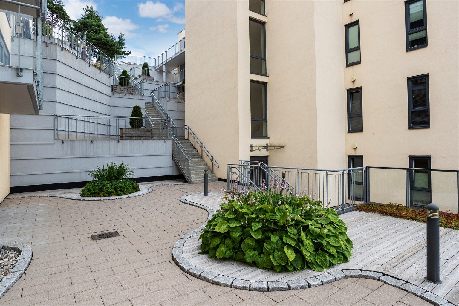 Sameiet har pent opparbeidede fellesarealer med beplantning og sitteplasser.