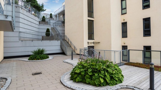 Sameiet har pent opparbeidede fellesarealer med beplantning og sitteplasser.