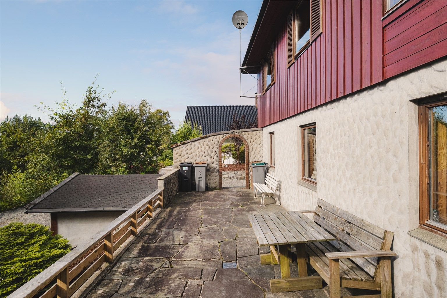 Uteområde på baksiden av huset med en frittstående utebod.