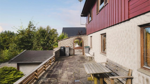 Uteområde på baksiden av huset med en frittstående utebod.