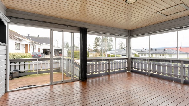 Romslig innglasset veranda med skyvedør ut til terrasse