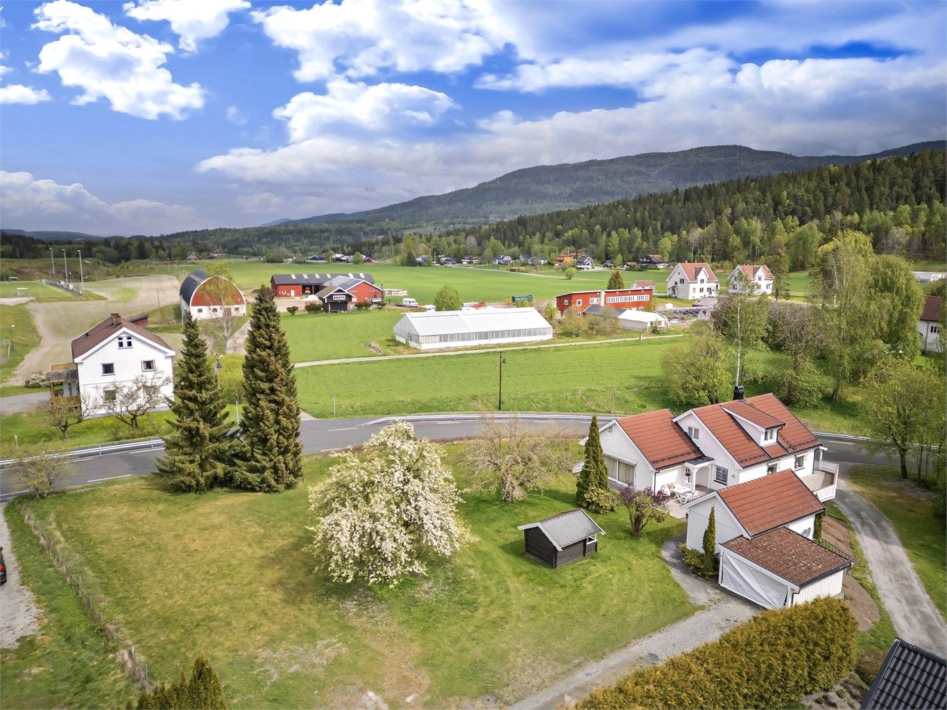 Enebolig med store garasje i kjeller og uthus/sidebygning. I tillegg følger separat tomt med egen adresse og egen innkjøring: Hellerudveien 19. Foto: Emotional Landscape Production Ole Thoresen
