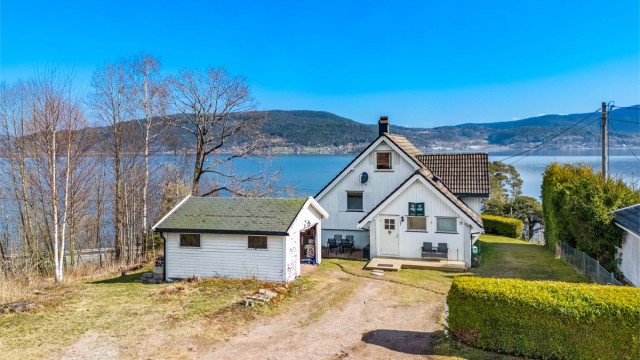 Eneboligen ligger på et høydedrag og har en usjenert tomt, bebygget med enebolig og frittstående garasje.