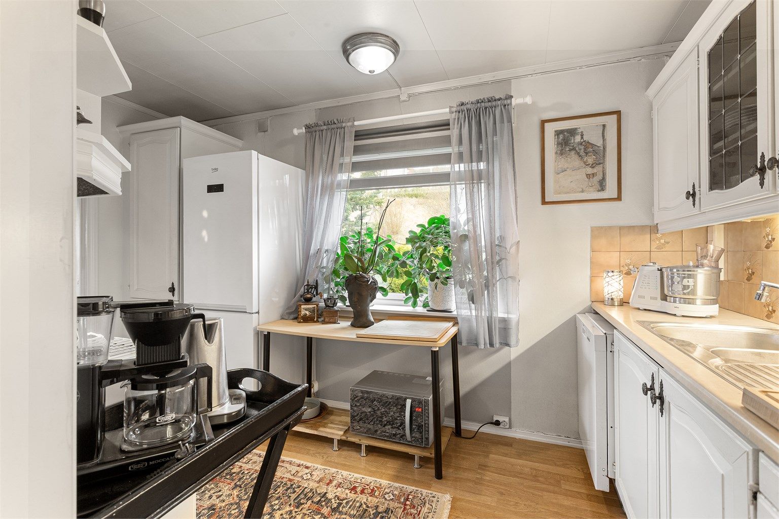 Over- og underskap samt vitrineskap og høyskap i hvit utførelse.