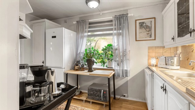 Over- og underskap samt vitrineskap og høyskap i hvit utførelse.