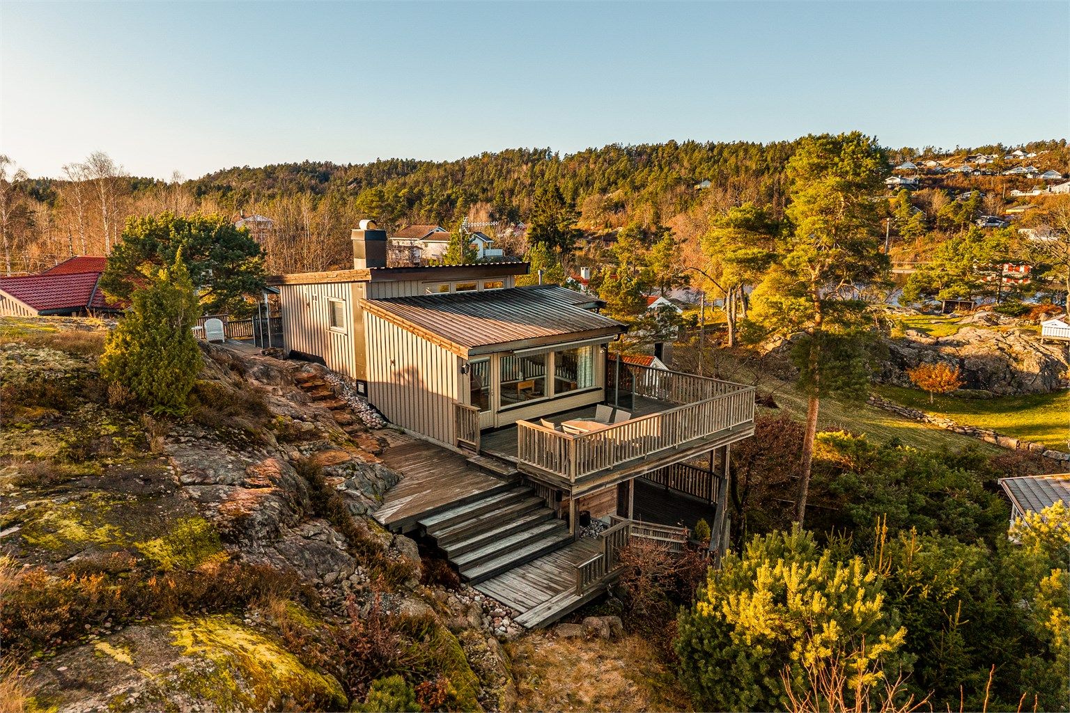 Fritidsboligen er fint tilpasset terrenget og har store terrasseflater i flere nivåer.