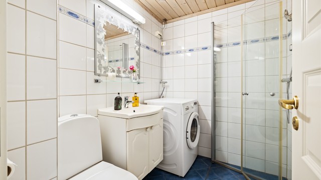 Badet har dusjhjørne med foldedører av glass og gulvvarme.