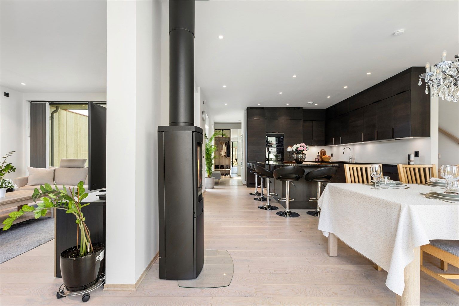 Den åpne løsningen mellom kjøkken, spisestue og stue skaper en sosial og innbydende atmosfære.