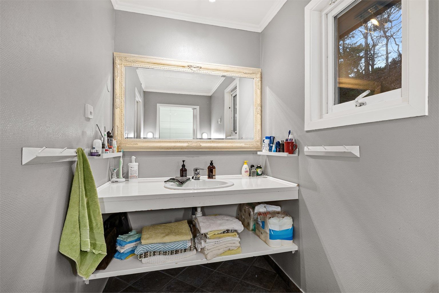 Bad med lagrinsplass og lyse overflater.