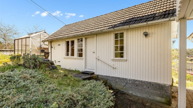 Koselig bryggerhus/anneks. Her er det behov for oppgradering. Drivhuset kan gjøre deg selvforsynt med grønnsaker. Kjekt når man er øyboer.
