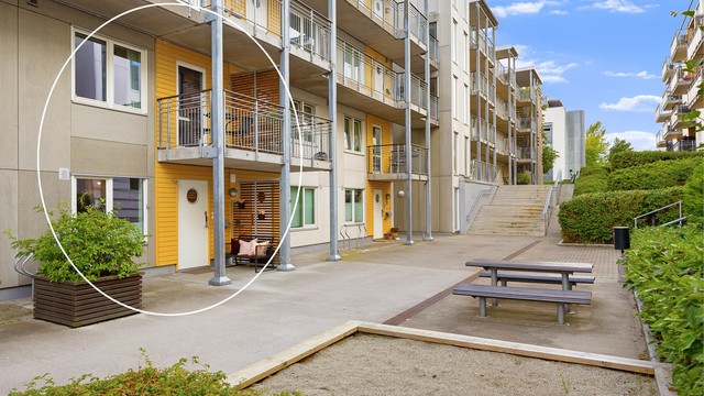 Fasade med inngangsparti - direkte inngang til leiligheten. Flere sandkasser for de minste rett utenfor døren.