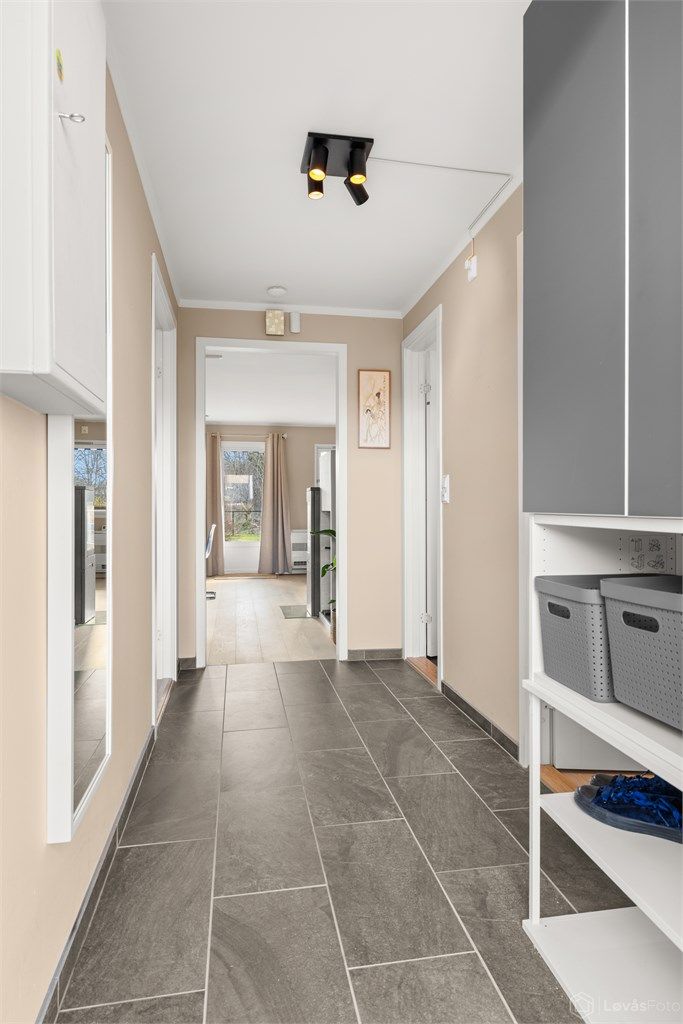 Entré med fliser og gulvvarme fornyet i 2024. Fra gangen er det en klar siktlinje gjennom leiligheten mot stuen og utgangen til terrassen, noe som gir en god romfølelse.