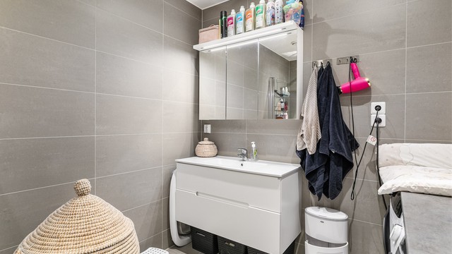 Grå fliser på både gulv og vegger gir badet helhet. I gulvet er det elektrisk varme.