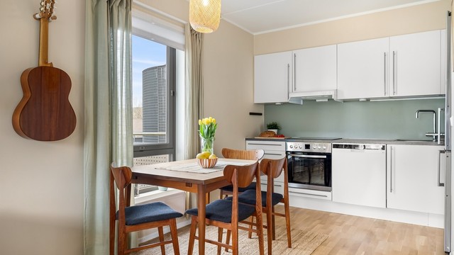 Kjøkkeninnredning med glatte, hvite fronter og laminatbenkeplate. Frittstående kjøleskap med fryser medfølger handelen, på lik linje med integrerte hvitevarer.