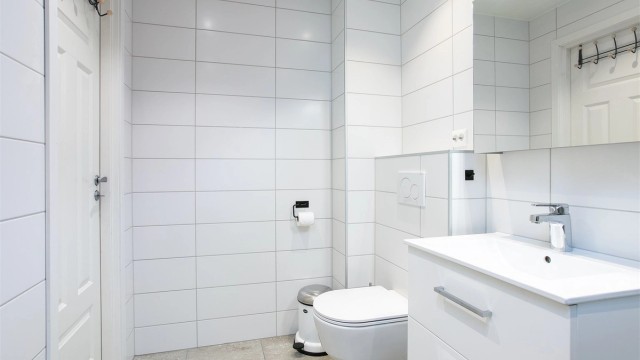 Innredning med servantskap og speilskap gir god oppbevaringsplass.