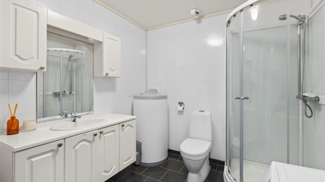 Badet er innredet med dusjkabinett, WC og servant. På badet er det også passert en varmtvannsbereder på ca. 190 liter.