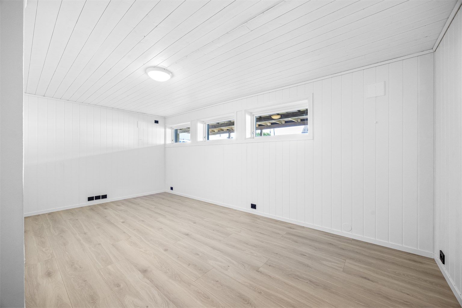 Oppusset kjellerstue med nytt elektrisk, laminatgulv og panel på veggene. Et allsidig rom, godkjent som hobbyrom i byggemeldte tegninger.