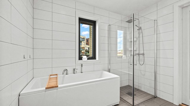 Badet er utstyrt med både badekar og et separat dusjhjørne med glassdører.