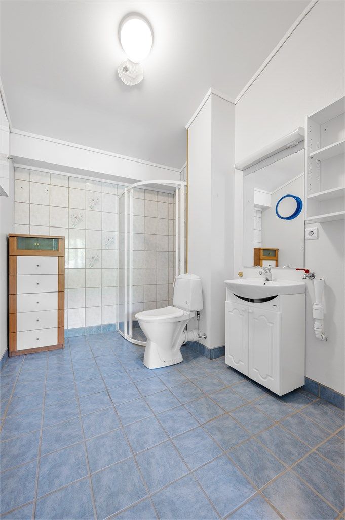 Badet har flislagt gulv med gulvvarme og opplegg for vaskemaskin.