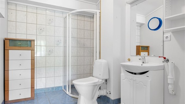 Badet har flislagt gulv med gulvvarme og opplegg for vaskemaskin.