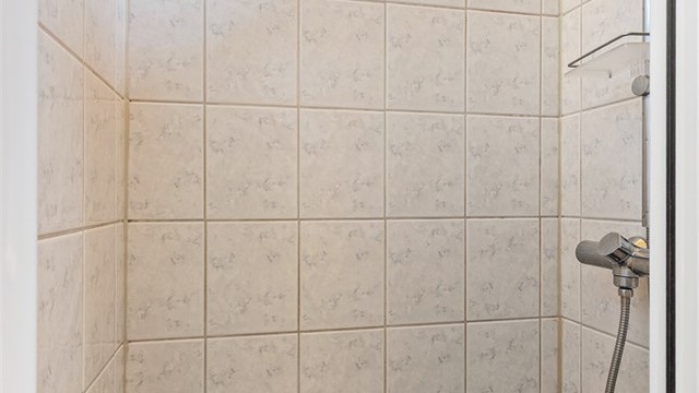 Dusjnisje med glassdør og ettgreps dusjarmatur.