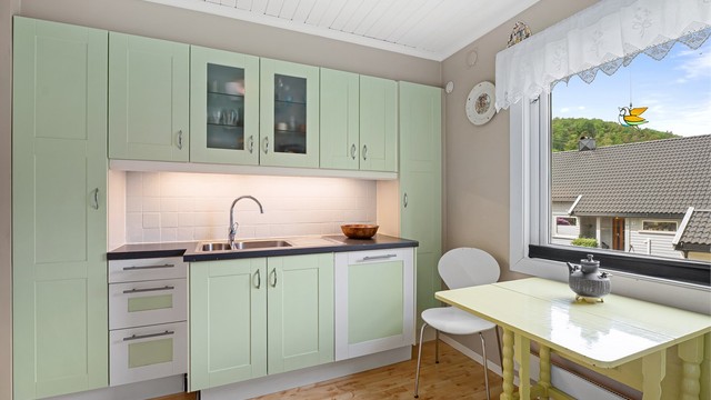 Separat kjøkken med plass til frokostbord med stort vindu som gjør rommet lyst og behagelig