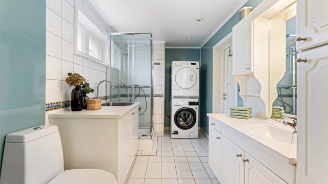 Flislagt baderom med gulvvarme og downlights. Opplegg for vaskemaskin og tørketrommel