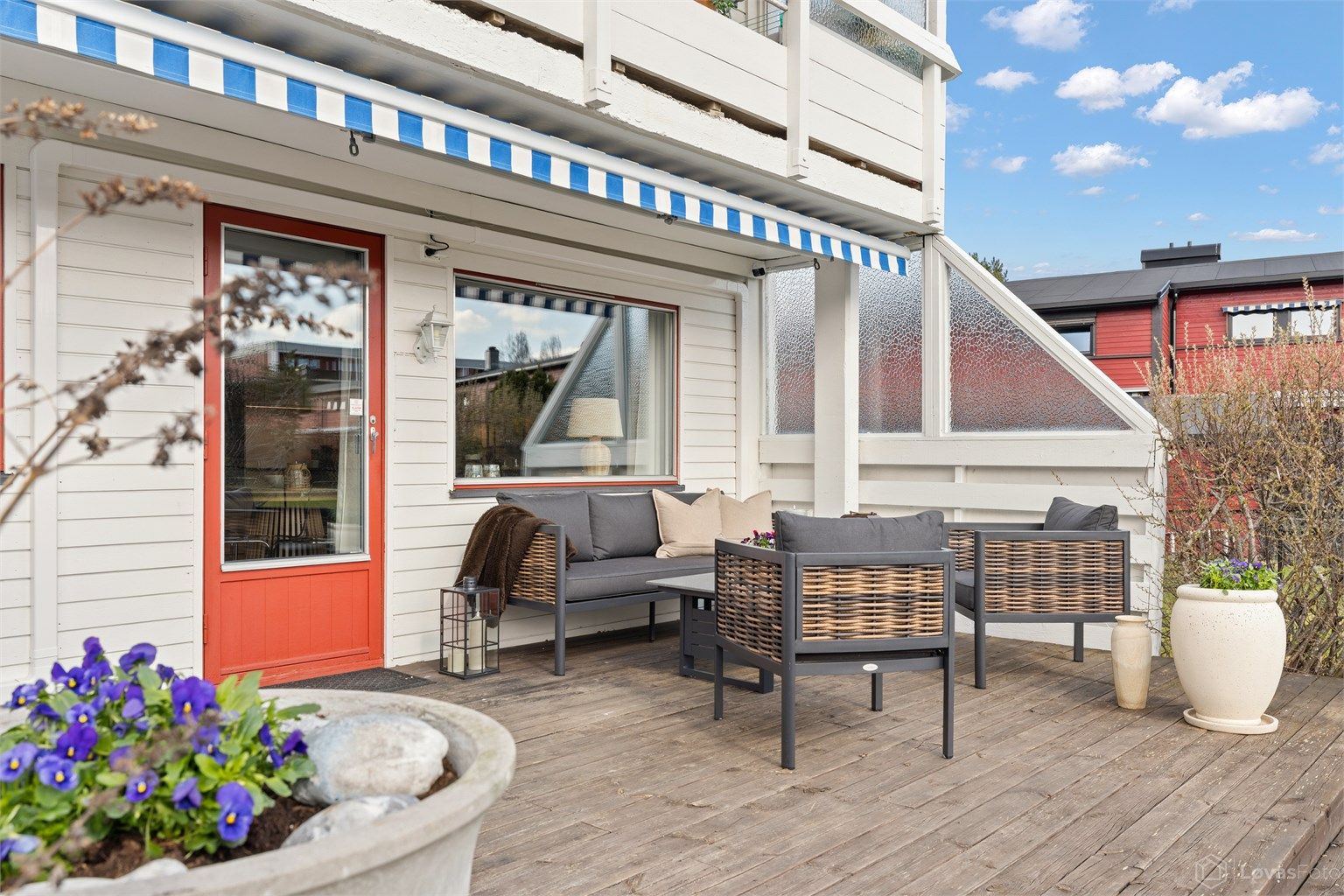 Terrassegulvet er belagt med trebord, og levegger i tre og glass gir skjerming.