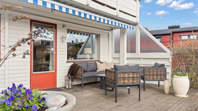 Terrassegulvet er belagt med trebord, og levegger i tre og glass gir skjerming.