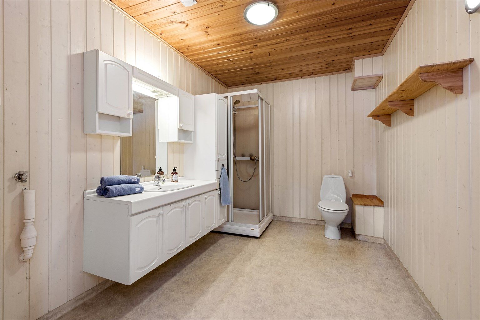 Bad i underetasjen fra 2002 med vinylbelegg m/gulvvarme, innredning, dusjkabinett og toalett. Opplegg for vaskemaskin.