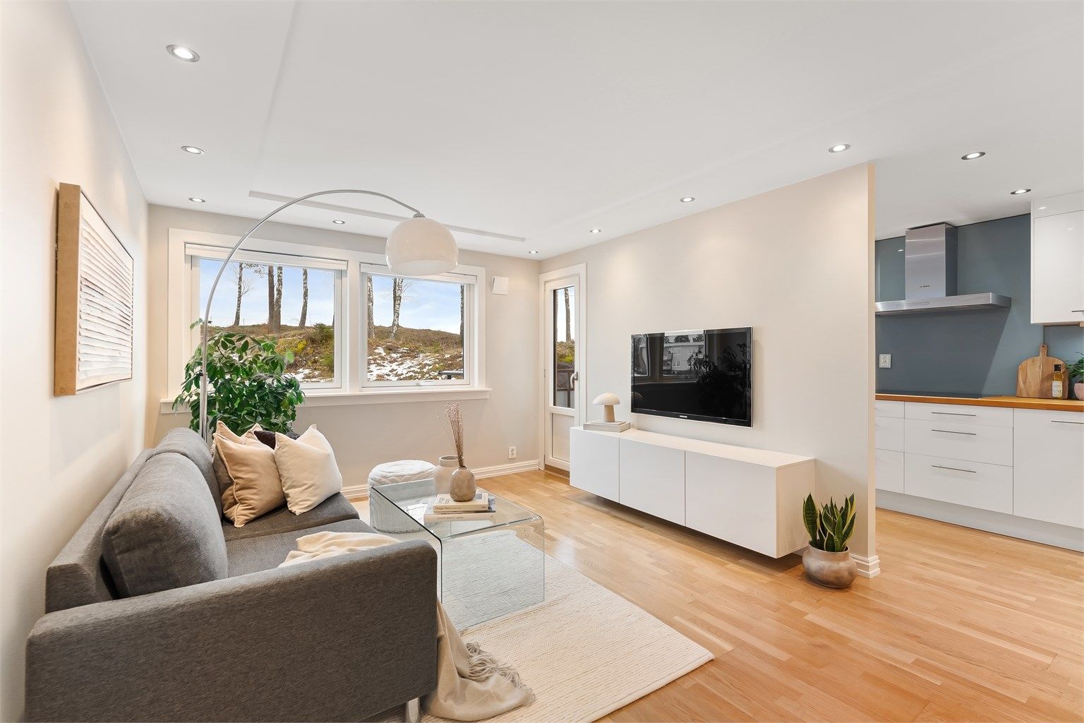 Stue og kjøkken er et lyst og sosialt rom med gjennomgående parkett og nedsenket himling med downlights.