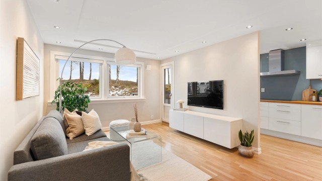Stue og kjøkken er et lyst og sosialt rom med gjennomgående parkett og nedsenket himling med downlights.