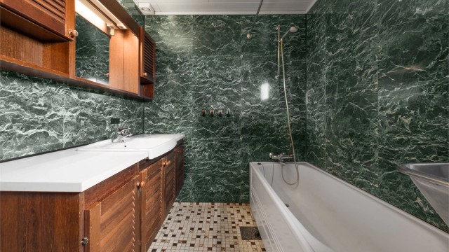 Baderomsinnredning med nedfelt servant og overskap med speil og belysning.