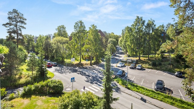 Fra stuen har man et luftig utsyn mot grønne omgivelser og nærområdet, med store vindusflater som gir rommet godt med naturlig lys.