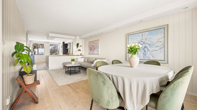 Den åpne løsningen mellom stue og kjøkken skaper en sosial og luftig atmosfære.