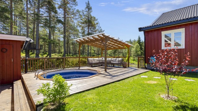 Stor terrasse på 45 m² med nedfelt oppvarmet basseng og pergola.
