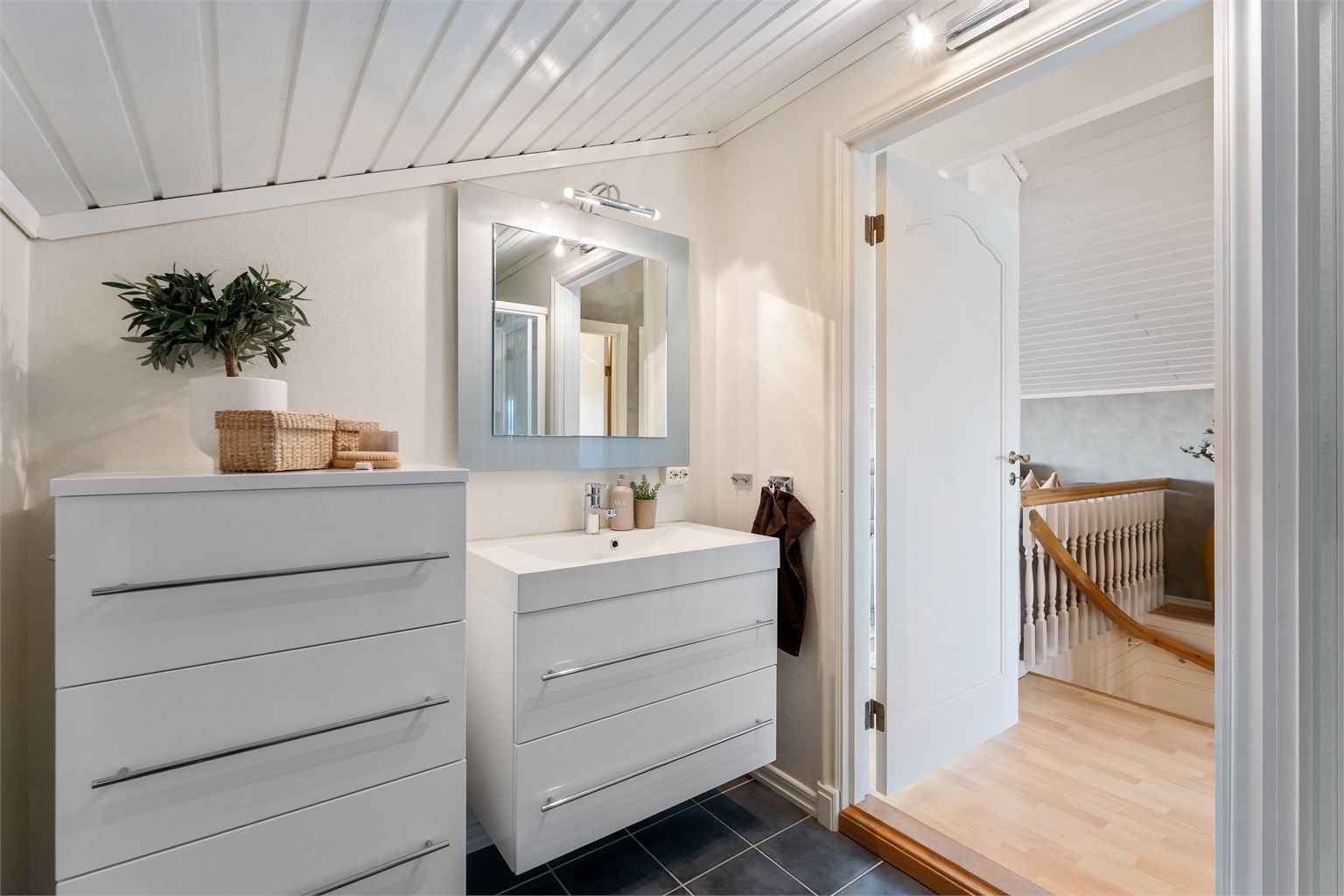 Rommet har vegghengt servantskap og ekstra skap for oppbevaring.