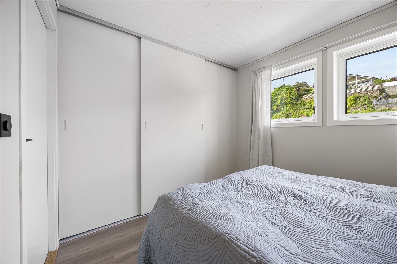 Rommet har en stor skyvedørsgarderobe for effektiv oppbevaring.