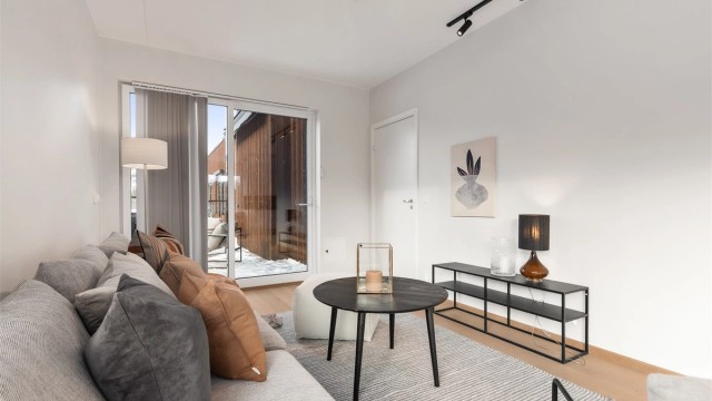 Stue med plass til sittegruppe og TV-område. Utgang til stor takterrasse.
