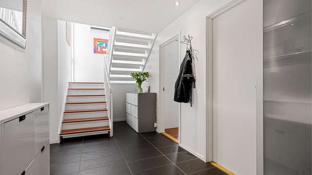 Romslig entré med fliser på gulv, varmekabler, malte vegger og spotter i tak. Garderobeskap med god oppbevaringsplass. Inngangspartiet er av meget god størrelse, og har også plass til barnevogn, om man skulle trenge det.