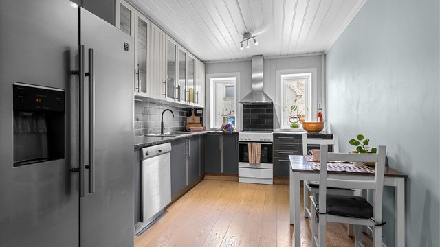 Kjøkken med innredning med glatte og profilerte fronter og benkeplate med laminert overflate med nedfelt kjøkkenvask