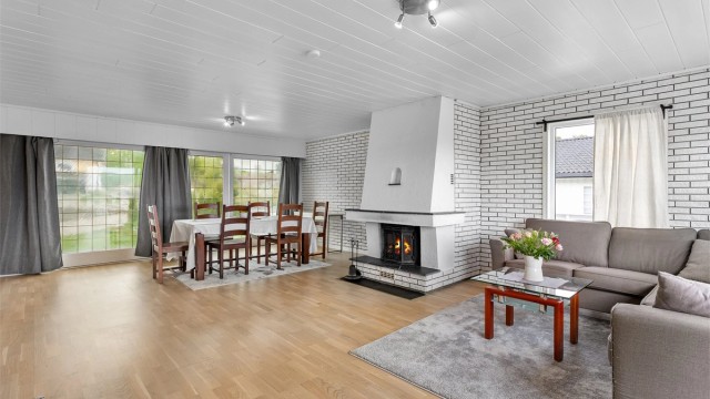 Stuen i hovedetasjen er romslig, med god plass til både sofagruppe og en egen spiseavdeling.