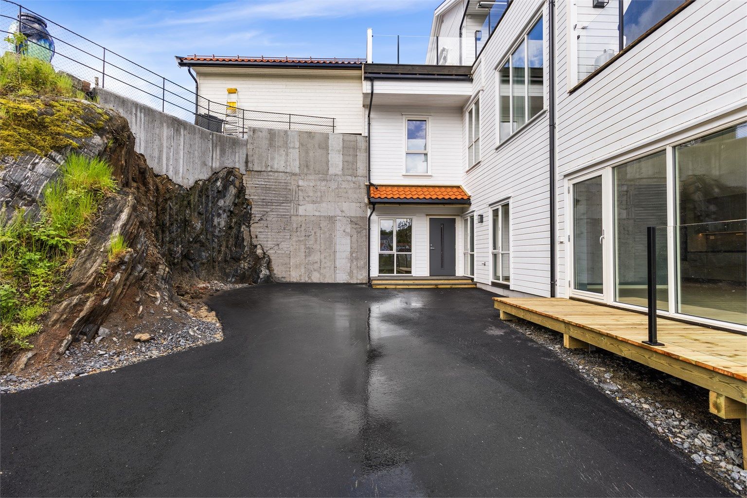 Asfaltert og lettstelt uteområde ved inngangspartiet.